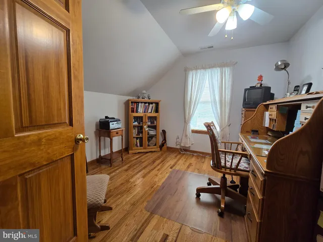 a view of a workspace with furniture and a window