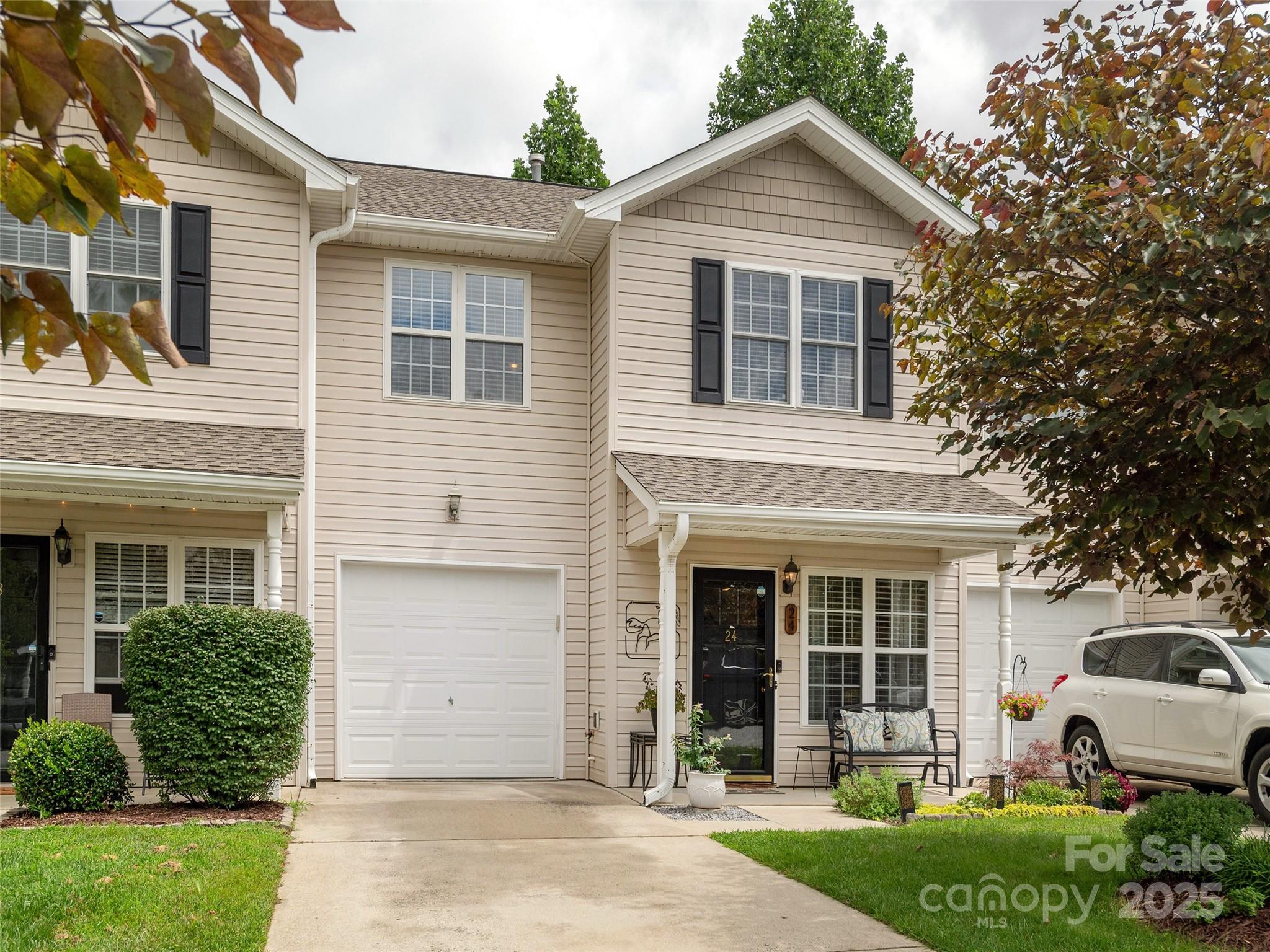 a view of a house with a yard and potted plants