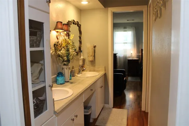 a bathroom with a sink and mirror with shower