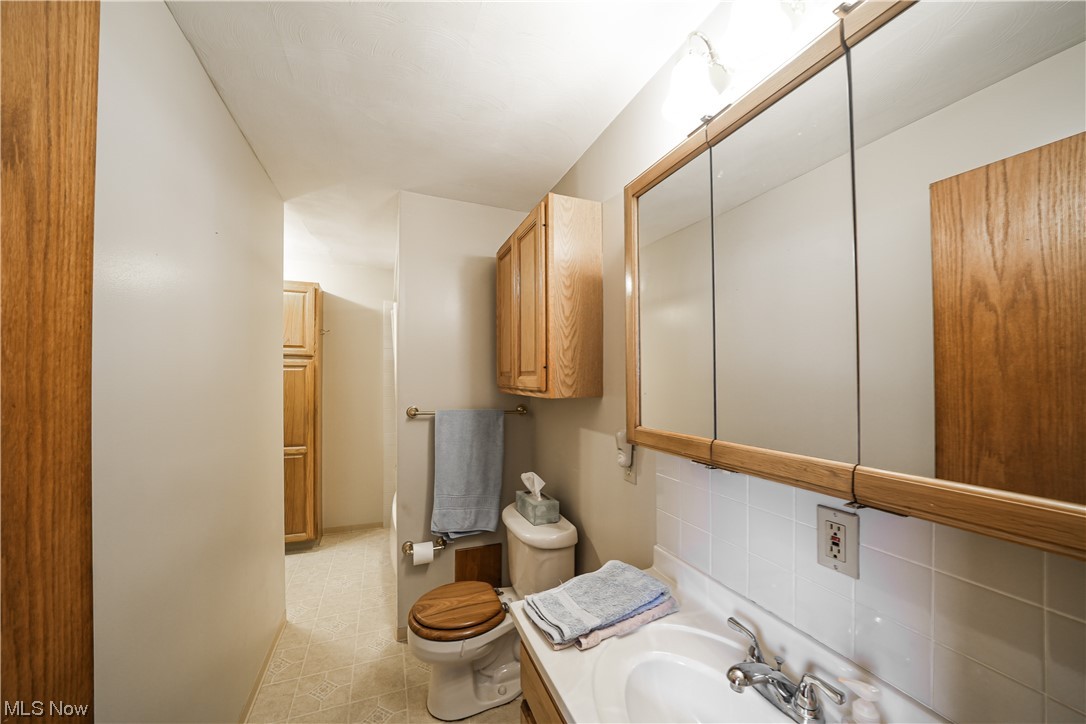 7541 Cooley Road Ravenna, OH 44266 - Photo 22 of 32 Bathroom featuring oversized vanity, toilet, tile floors, and backsplash