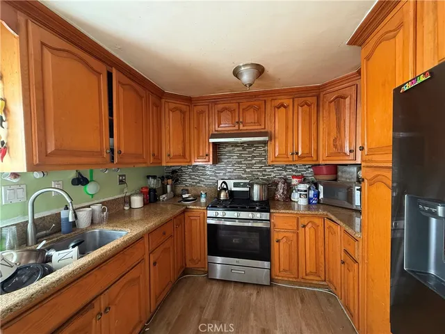 a kitchen with stainless steel appliances granite countertop a refrigerator and a stove top oven