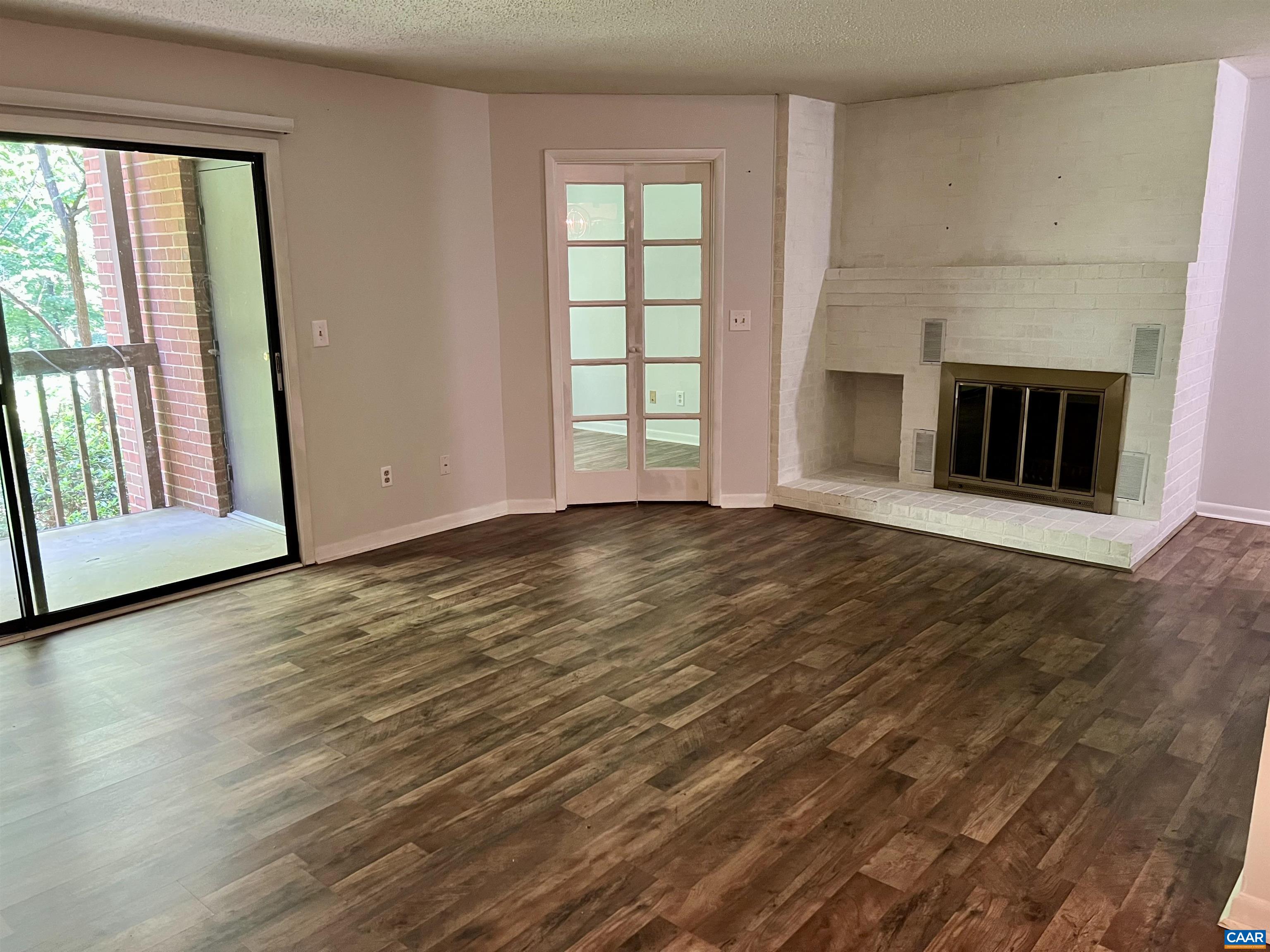 117 Turtle Creek Road, Unit 6 Charlottesville, VA 22901 - Photo 1 of 15 Wood burning fireplace and deck looking into woods from living room