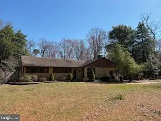 a front view of a house with a yard covered with trees