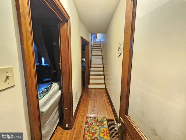 a view of a hallway with wooden floor and stairs