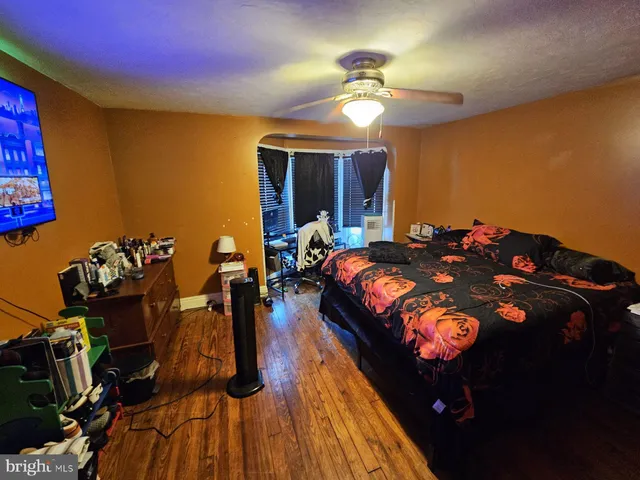 a bedroom with bed and wooden floor