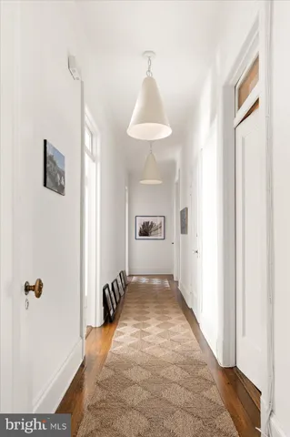 a view of a hallway with closet and a window