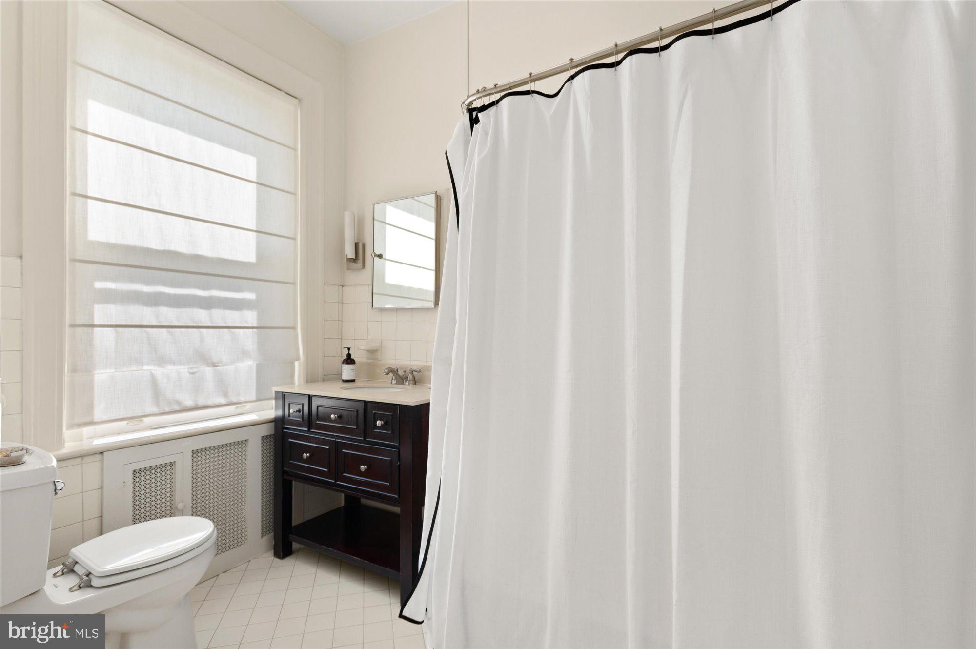 2029 Connecticut Avenue Northwest, Unit 42 Washington, DC 20008 - Photo 20 of 37 a bathroom with a sink a toilet and a window