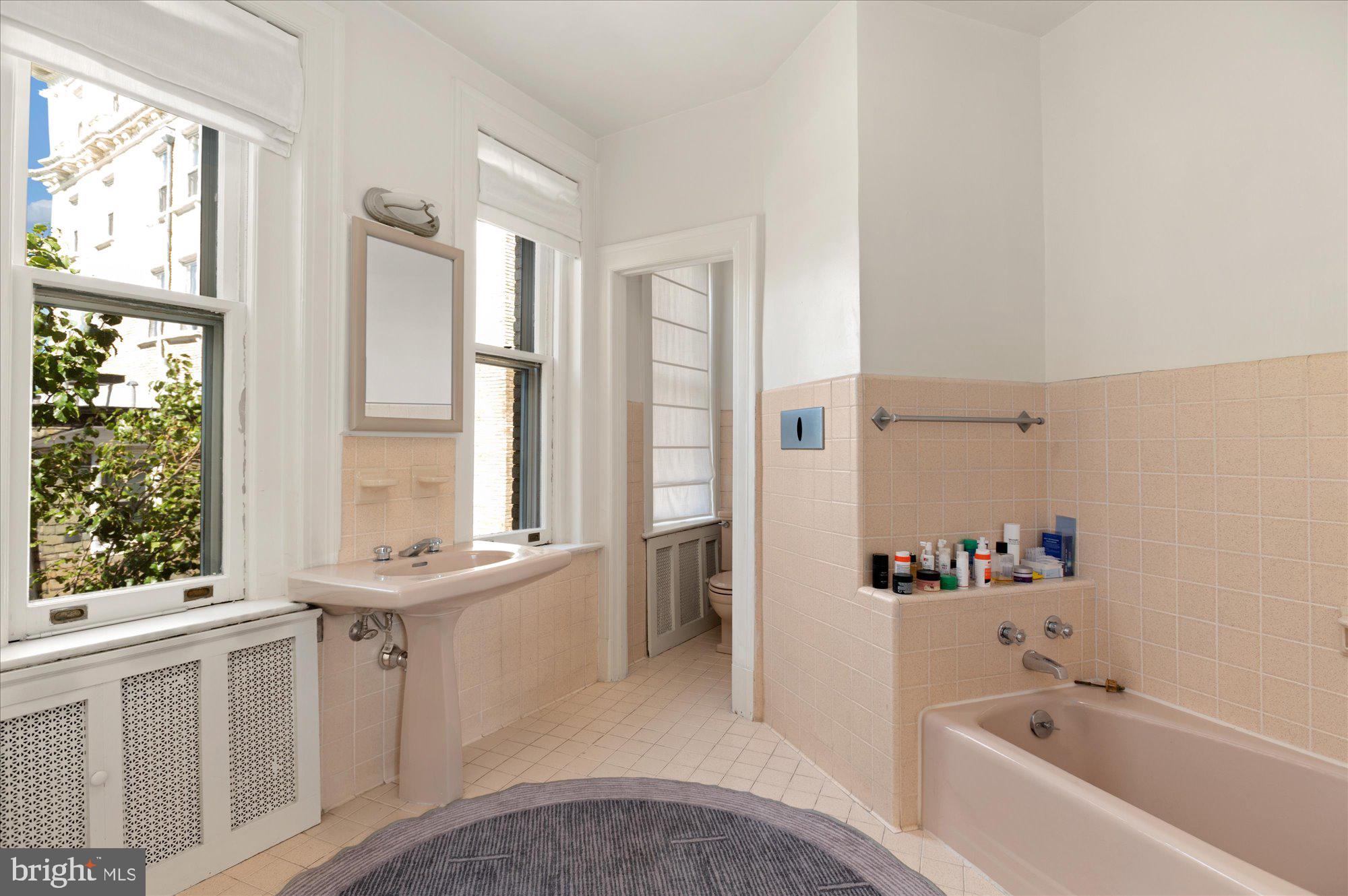 2029 Connecticut Avenue Northwest, Unit 42 Washington, DC 20008 - Photo 25 of 37 a bathroom with a bathtub sink and mirror