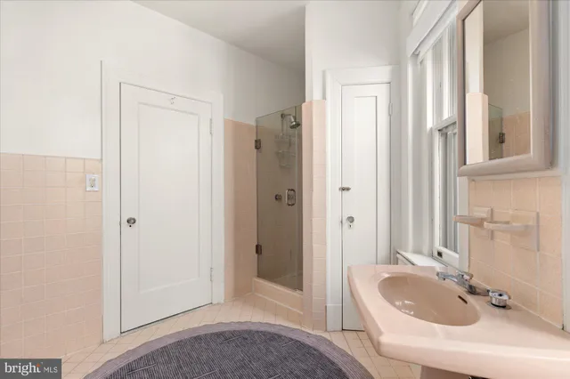 a bathroom with a tub sink and mirror