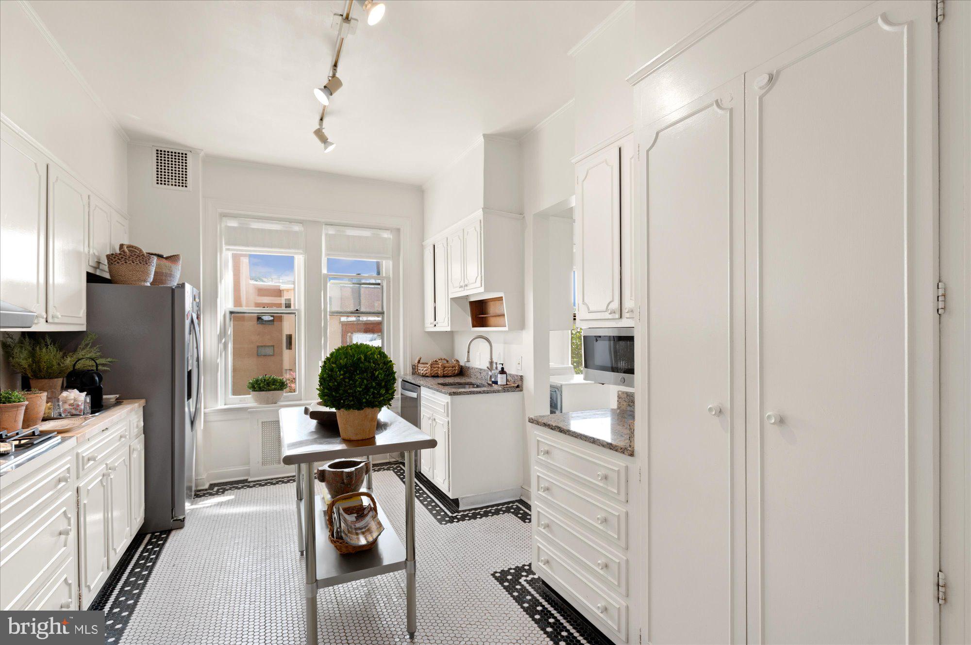 2029 Connecticut Avenue Northwest, Unit 42 Washington, DC 20008 - Photo 4 of 37 a view of a kitchen with kitchen island granite countertop a refrigerator stove microwave and furniture