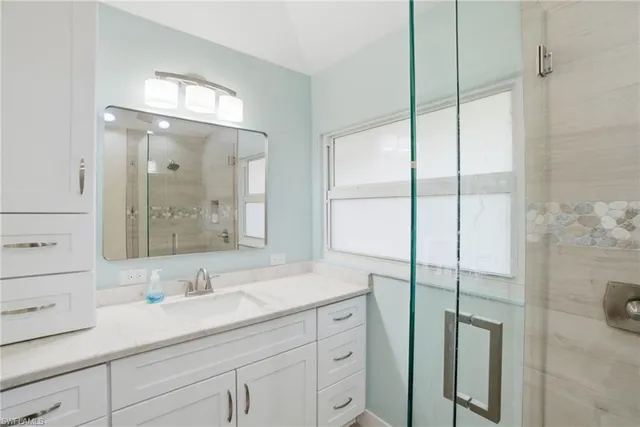 a bathroom with a shower sink and mirror