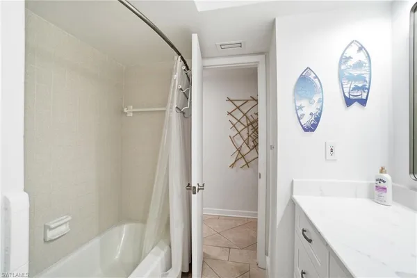 a bathroom with a tub sink and mirror