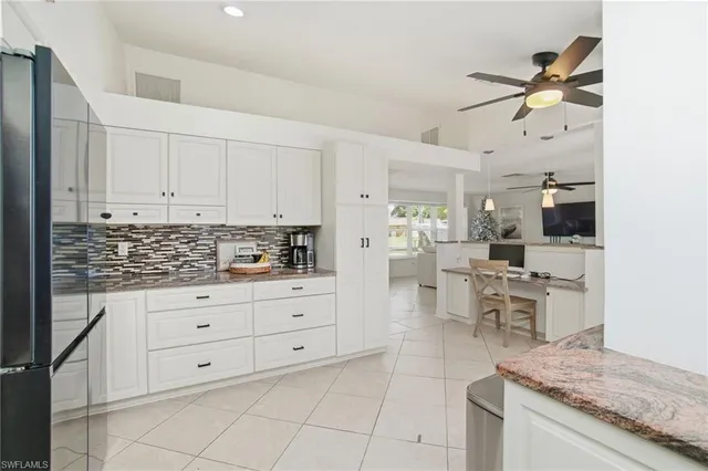 a kitchen with white cabinets and appliances