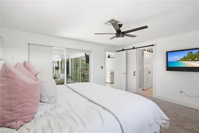 a bedroom with a large bed and a ceiling fan