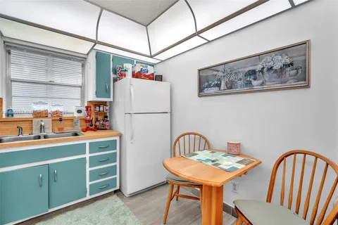 a utility room with dryer cabinets and wooden floor