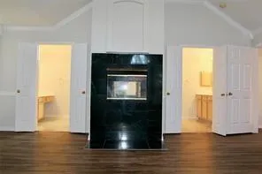 a view of a hallway with wooden floor and a fireplace