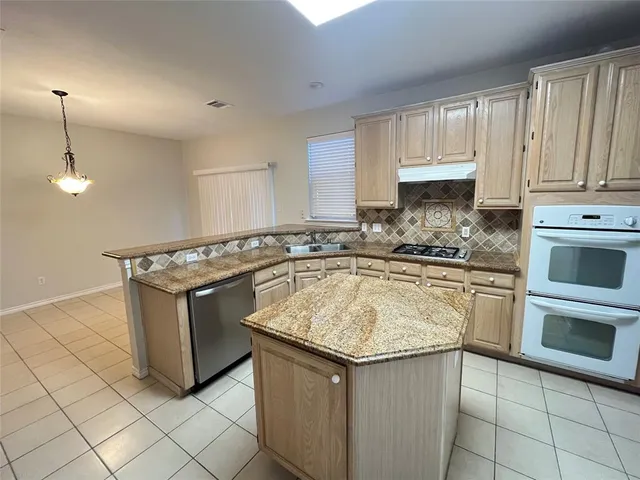 a kitchen with granite countertop a sink stove and cabinets