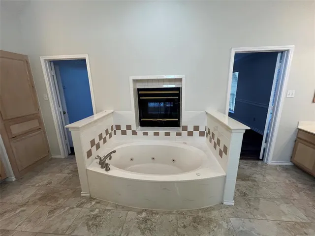 a bathroom with a bathtub and a window