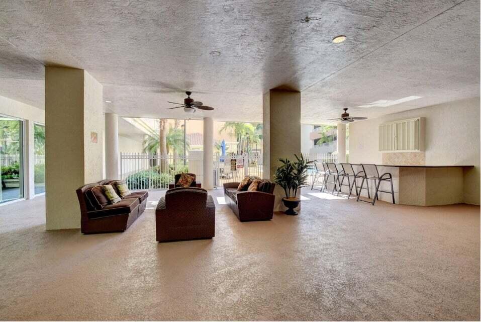 1690 Renaissance Commons Boulevard, Unit 1522 Boynton Beach, FL 33426 - Photo 27 of 31 a living room with furniture and large windows