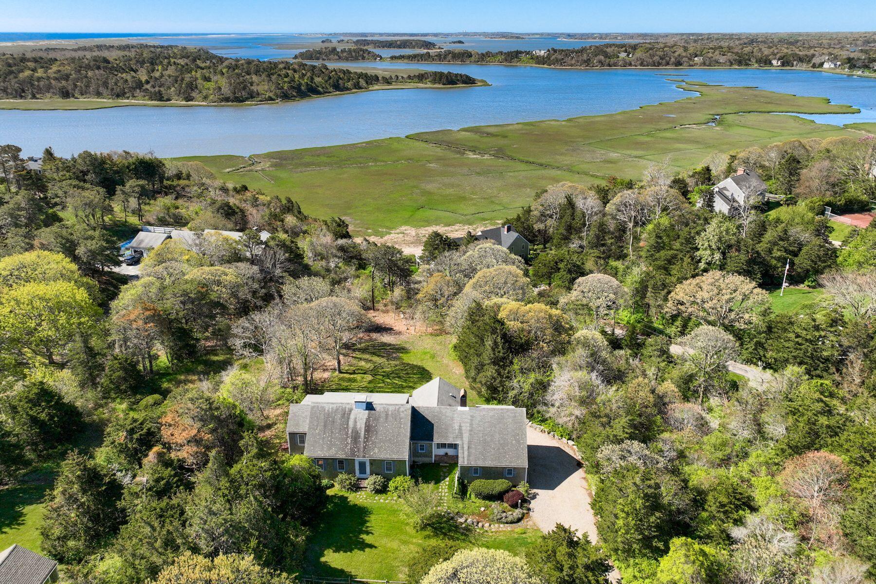 an aerial view of residential houses with outdoor space and lake view