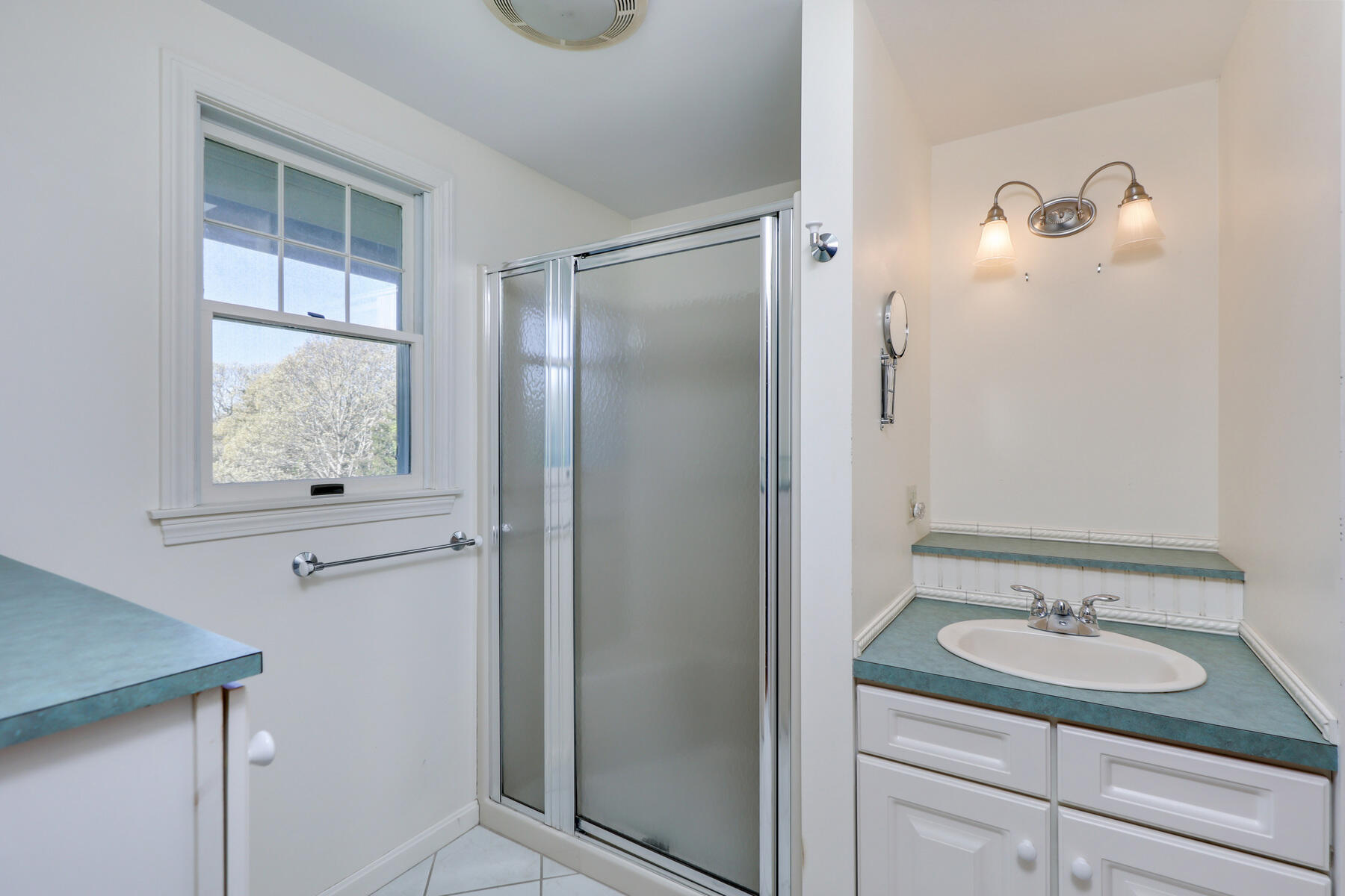 39 Sparrowhawk Road Orleans, MA 02653 - Photo 18 of 40 a bathroom with a granite countertop sink a mirror and shower