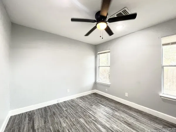 a view of empty room with wooden floor