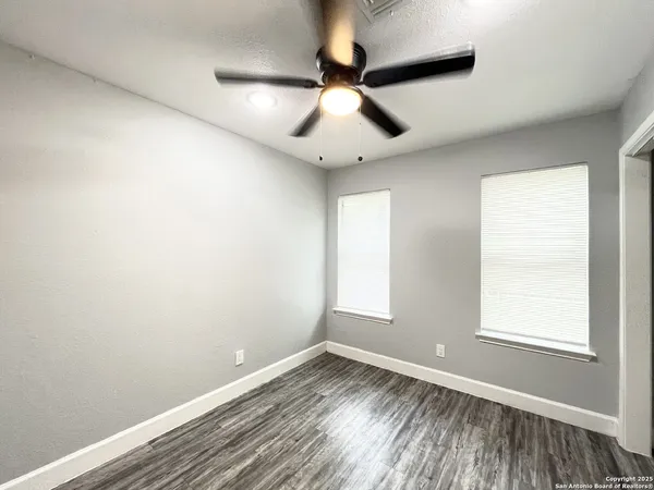 an empty room with wooden floor a ceiling fan and closet