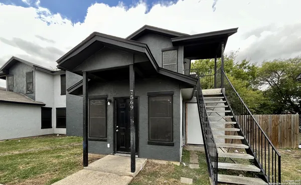 a view of a house with wooden fence