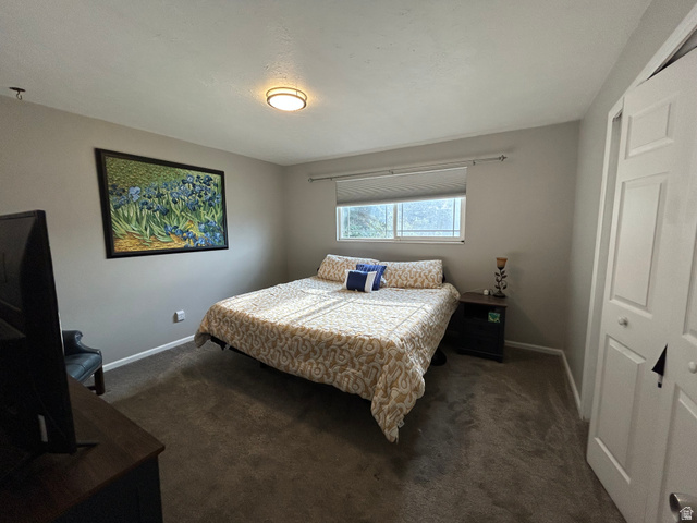 7659 State Street Midvale, UT 84047 - Photo 9 of 33 Bedroom featuring dark colored carpet and a closet