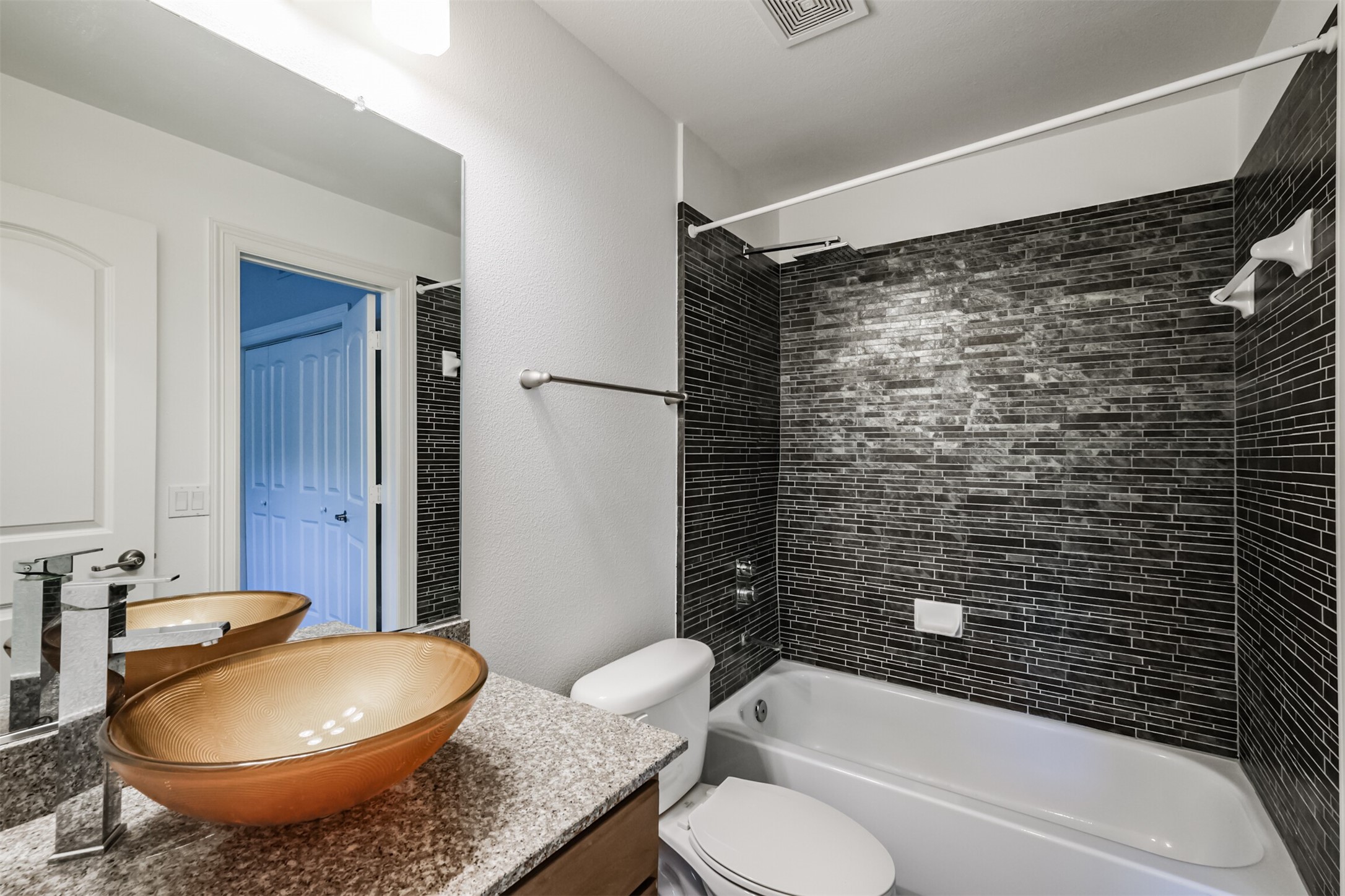 3501 Chenevert Street, Unit 7 Houston, TX 77004 - Photo 16 of 24 a bathroom with a granite countertop sink toilet mirror and bathtub