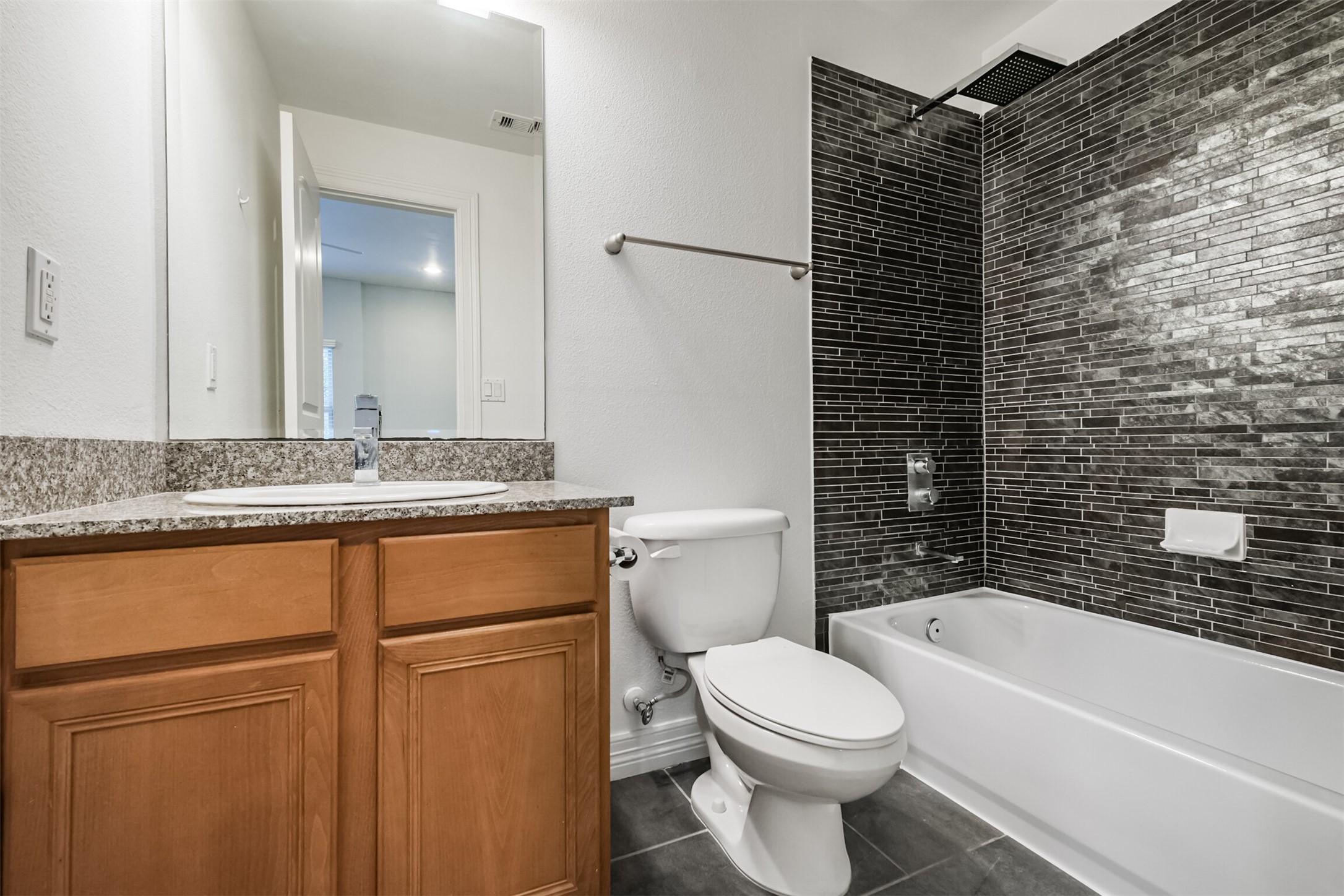 3501 Chenevert Street, Unit 7 Houston, TX 77004 - Photo 22 of 24 a bathroom with a granite countertop toilet sink and mirror