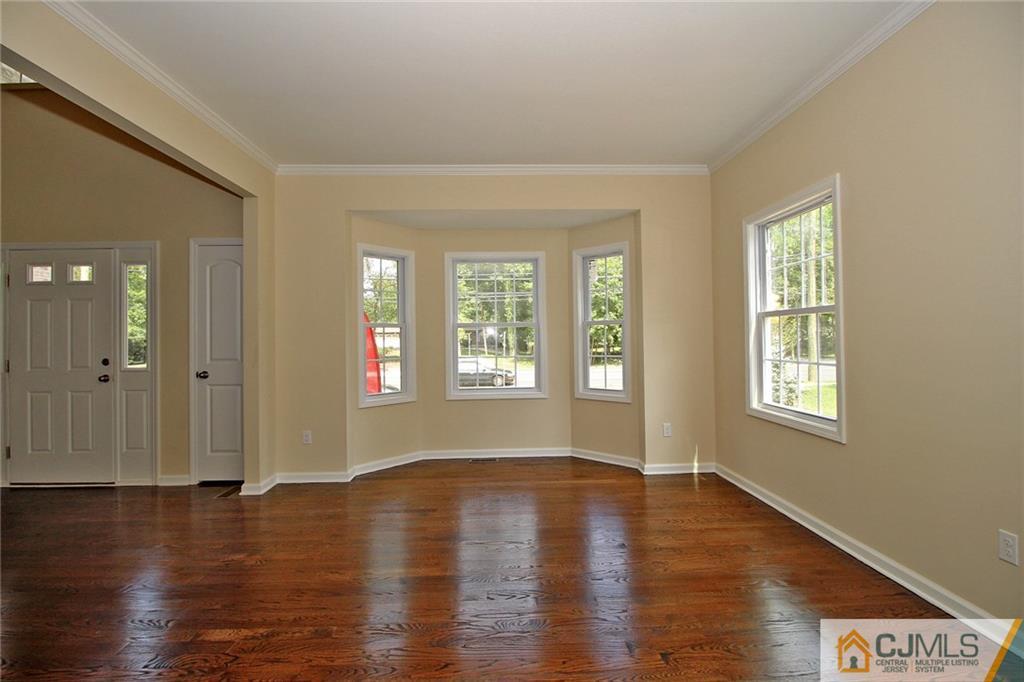301 Plainfield Road Edison, NJ 08820 - Photo 11 of 25 an empty room with wooden floor and windows with curtains