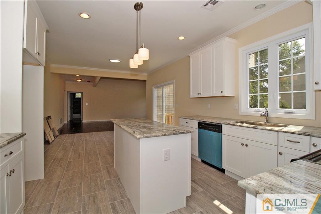 301 Plainfield Road Edison, NJ 08820 - Photo 13 of 25 a kitchen with granite countertop a sink stove and cabinets