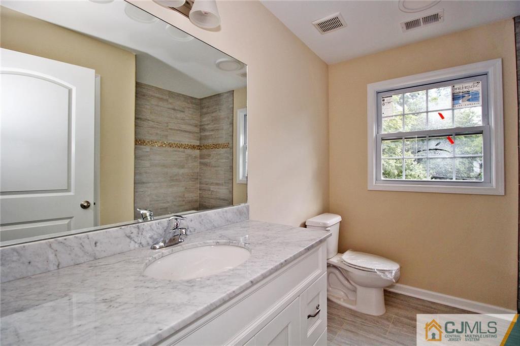 301 Plainfield Road Edison, NJ 08820 - Photo 24 of 25 a bathroom with a granite countertop toilet sink and mirror