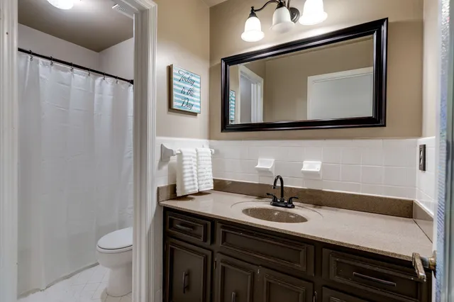 a bathroom with a toilet a sink and mirror