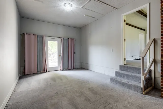 a view of room with stairs and a refrigerator