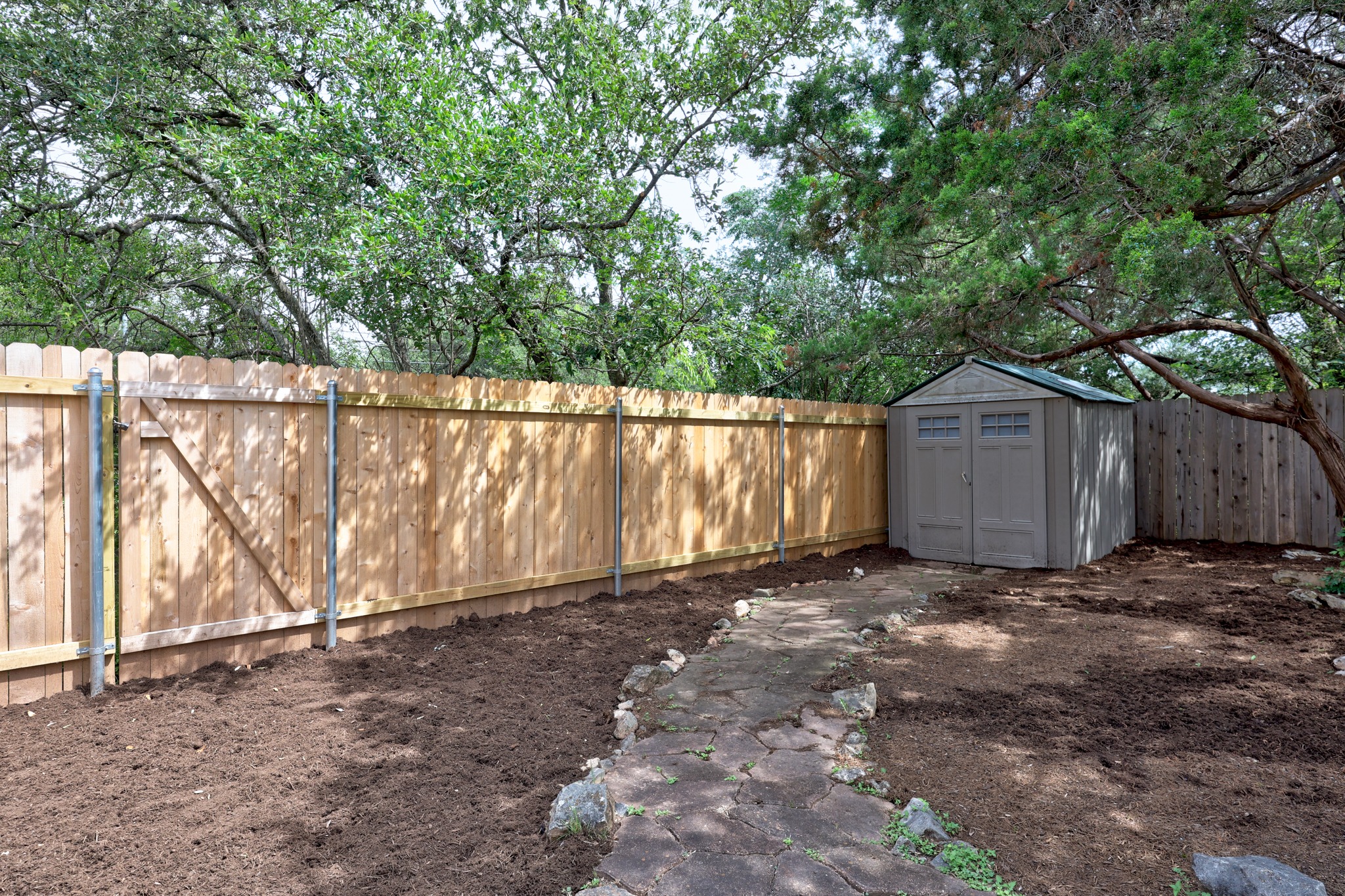 8219 Edgemoor Place Austin, TX 78749 - Photo 28 of 30 Xeriscaped areas with freshly mulched backyard ready for you to add your own touch of garden art all the while keeping your garden tools in the shed.