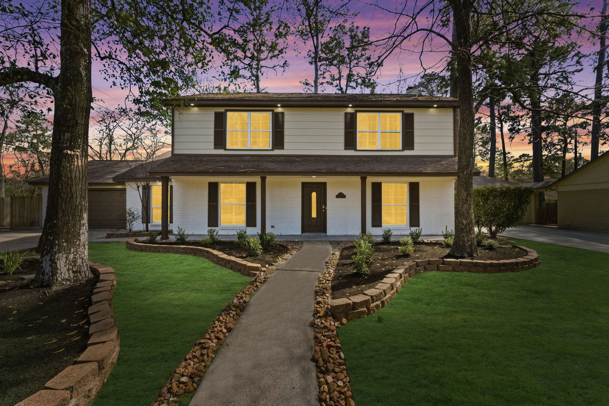 Your stunning new chapter begins here. Welcome to 5203 Woodville Lane, a charming two-story traditional residence. Set on a large, wooded lot with mature trees, the home features a freshly painted exterior, classic dark shutters, and an inviting covered front porch.