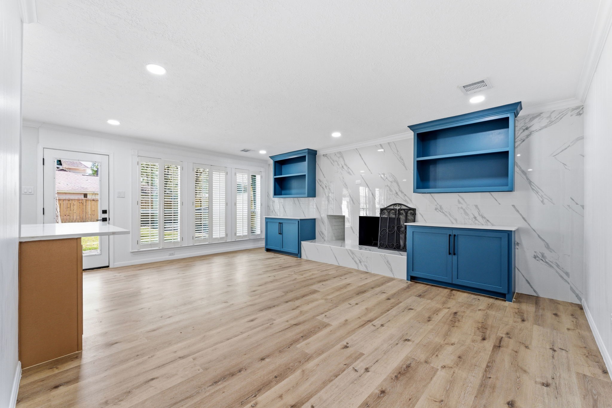 5203 Woodville Lane Spring, TX 77379 - Photo 12 of 50 Relax by the stunning marble-clad fireplace, flanked by custom built-ins in a striking designer blue.