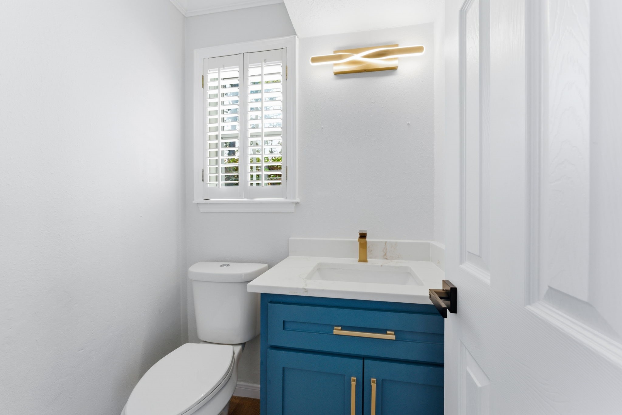 5203 Woodville Lane Spring, TX 77379 - Photo 26 of 50 Even the powder room makes a statement with a bold navy vanity, chic gold hardware, and contemporary lighting.
