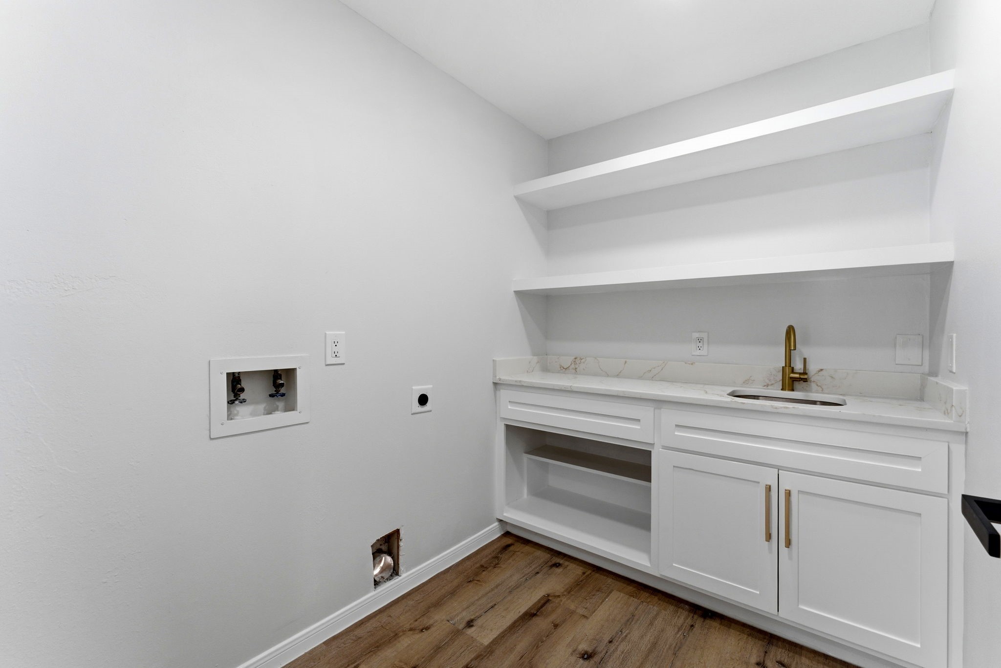 5203 Woodville Lane Spring, TX 77379 - Photo 27 of 50 Luxury in the little things. Who knew a laundry room could be a vibe? With gold accents and a marble-look countertop, even "Laundry Day" feels like a spa day for your wardrobe.