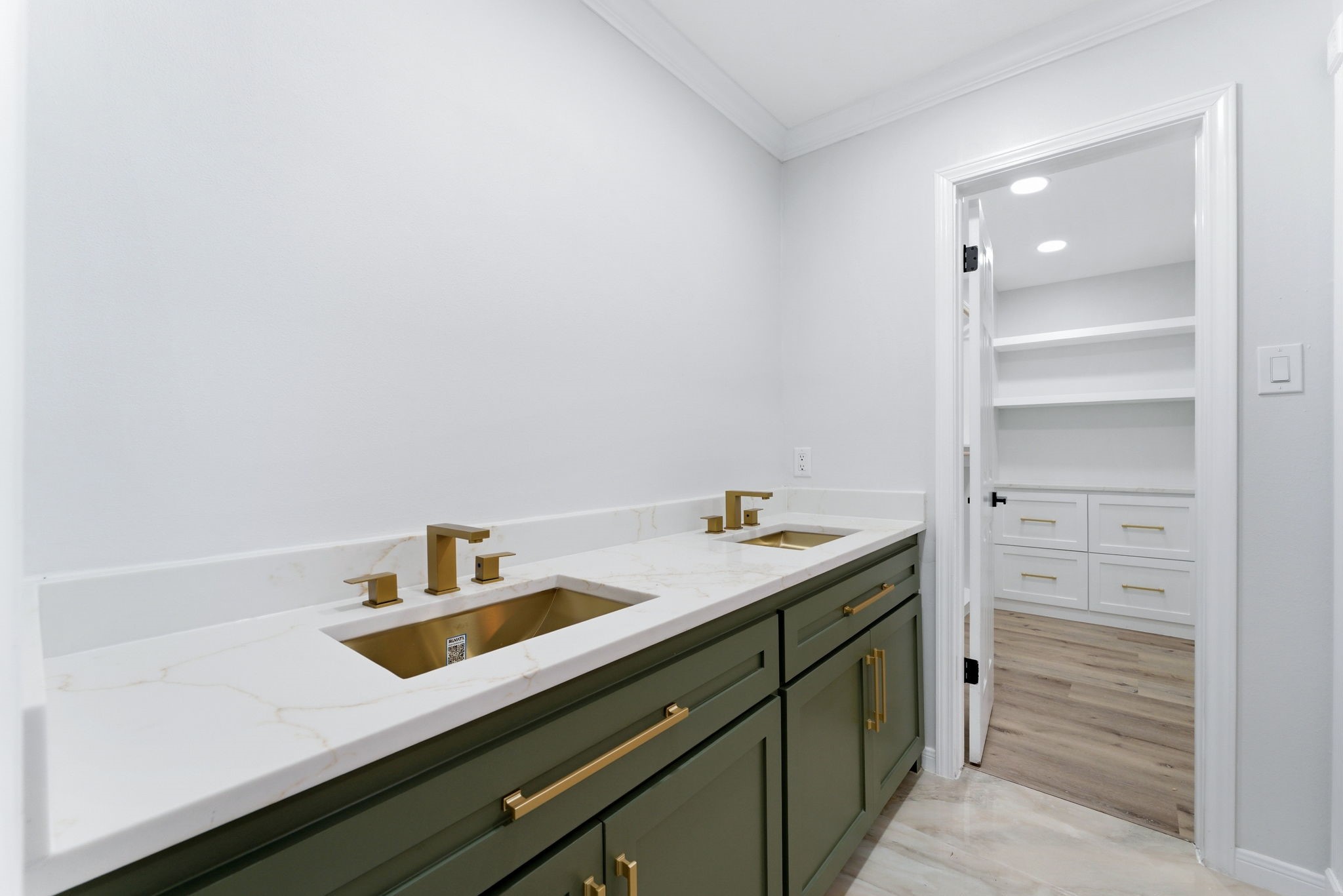 5203 Woodville Lane Spring, TX 77379 - Photo 31 of 50 A bold statement in design. Deep forest green cabinetry meets stunning gold hardware and dual basins for a vanity that is as functional as it is fashionable.