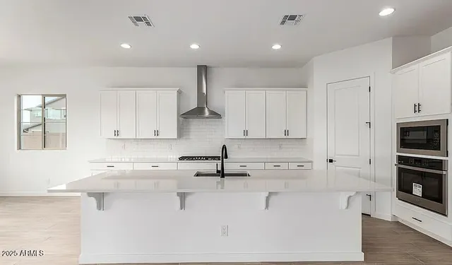 a kitchen with kitchen island sink stove and cabinets