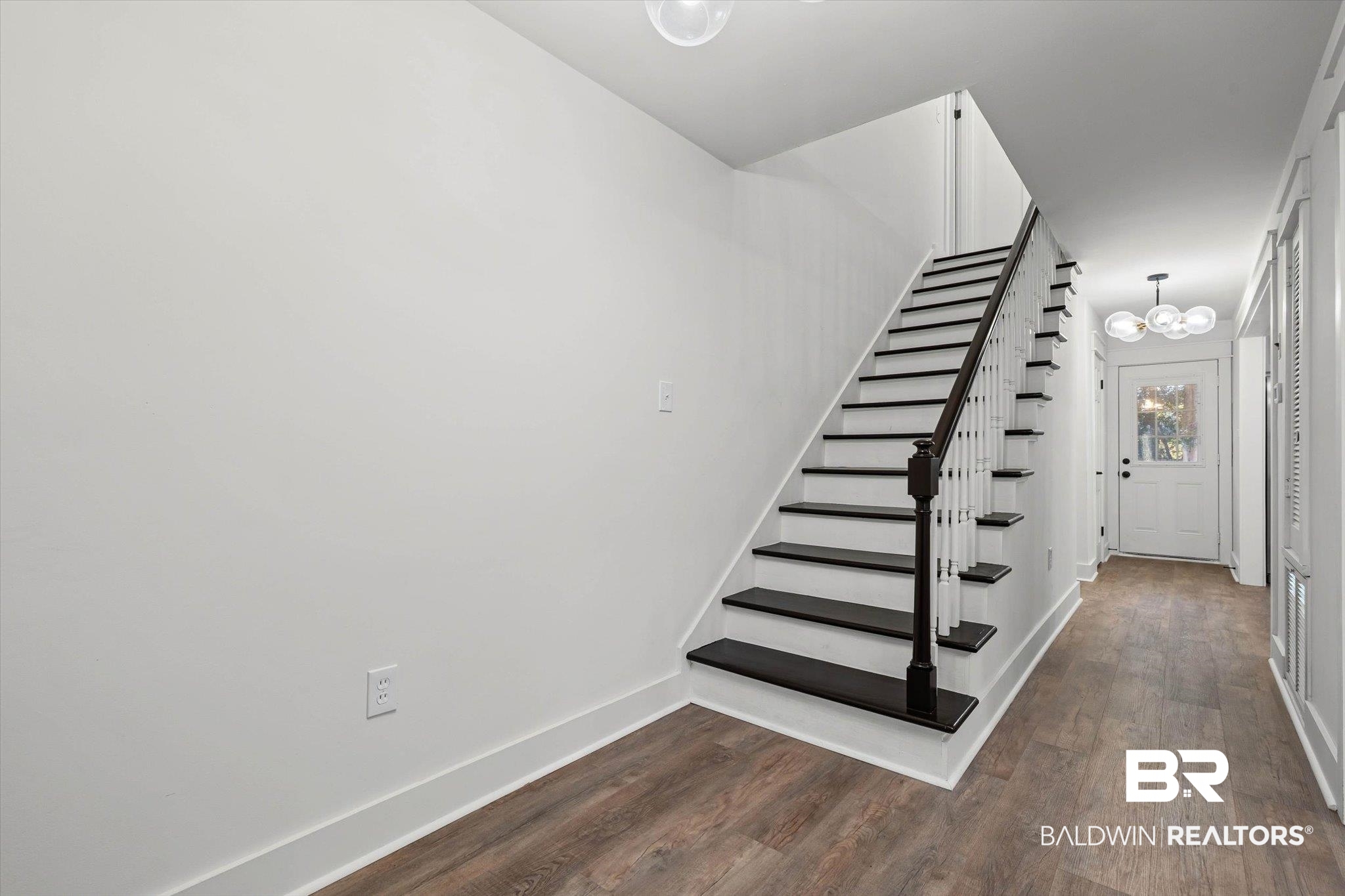 3933 Radnor Avenue Mobile, AL 36608 - Photo 17 of 36 Stairs featuring wood finished floors and a chandelier.