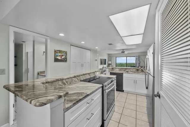 a kitchen with stainless steel appliances granite countertop a sink and a refrigerator