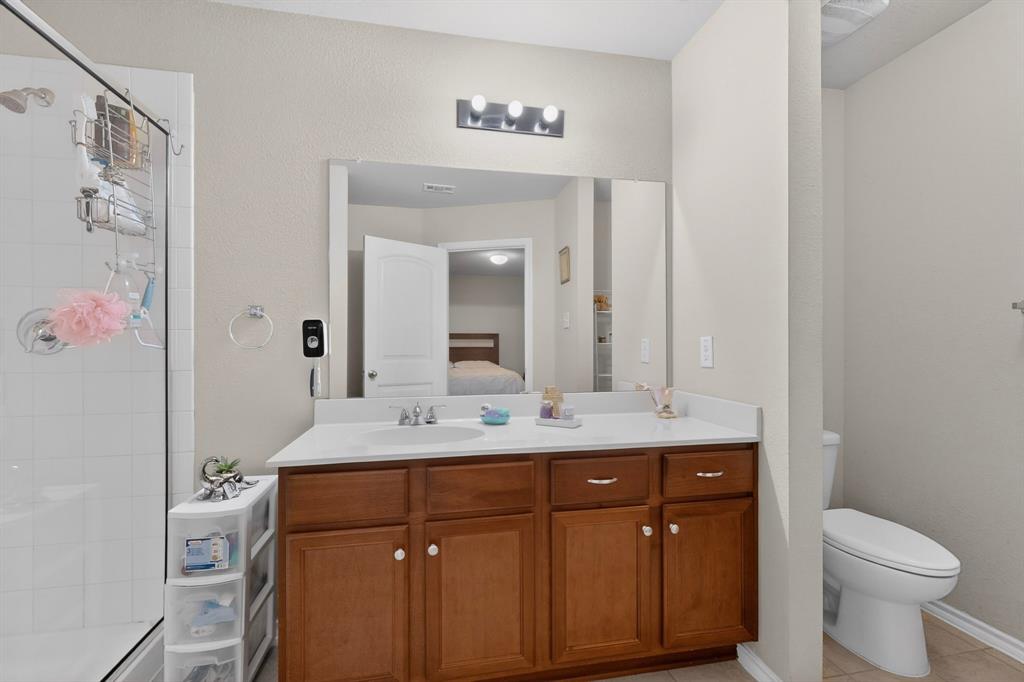 1409 Slate Street Princeton, TX 75407 - Photo 21 of 36 Bathroom featuring a wood-finish vanity with a single sink, an integrated mirror, and overhead vanity lighting
