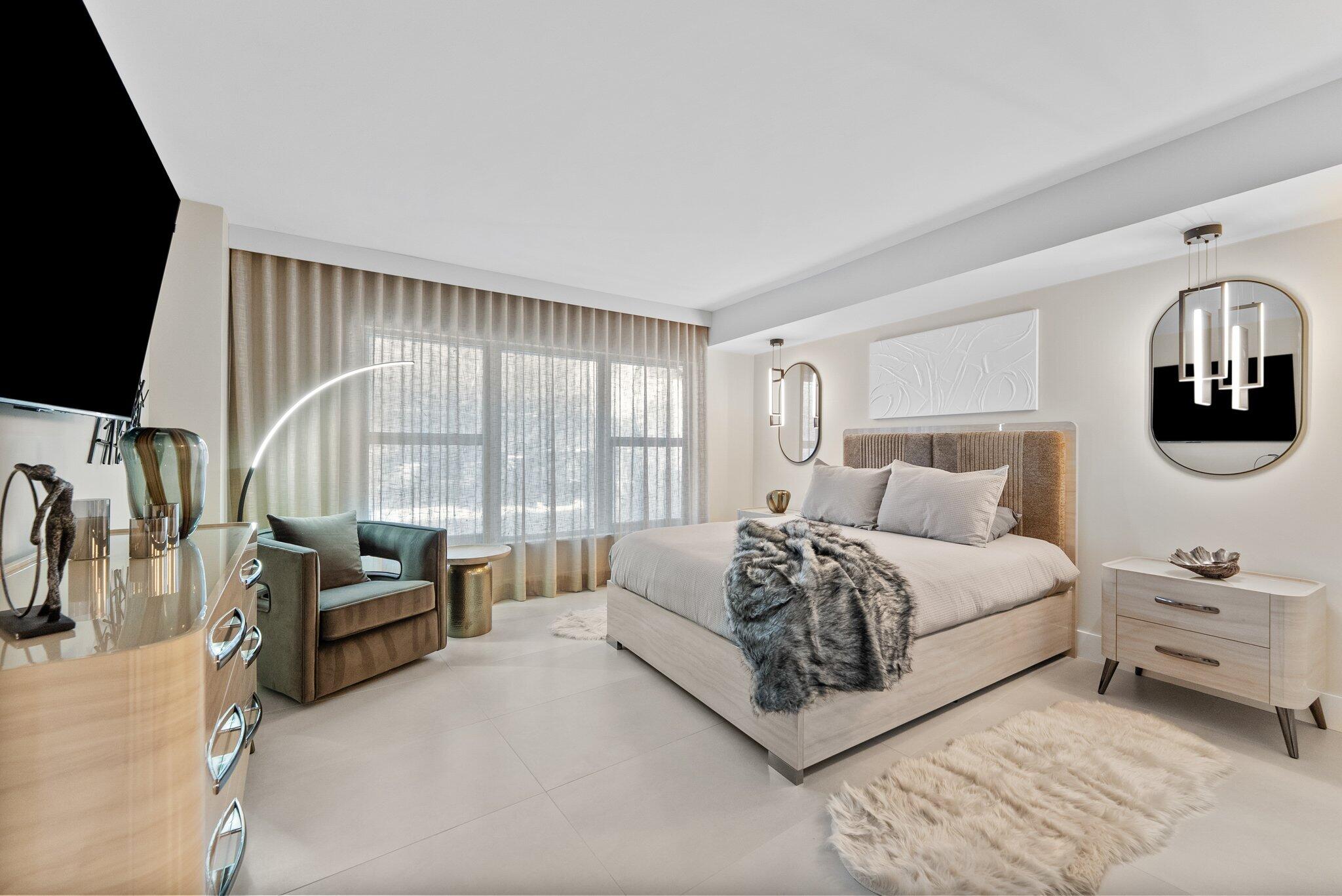 875 East Camino Real, Unit 2G Boca Raton, FL 33432 - Photo 15 of 55 a spacious bedroom with a bed a couch and a flat tv screen