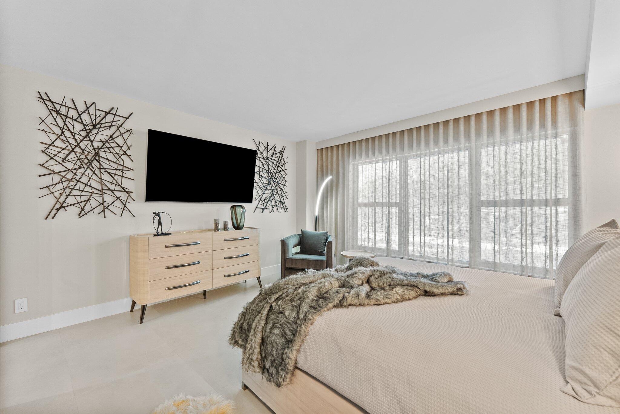 875 East Camino Real, Unit 2G Boca Raton, FL 33432 - Photo 17 of 55 a bedroom with a bed and a flat screen tv