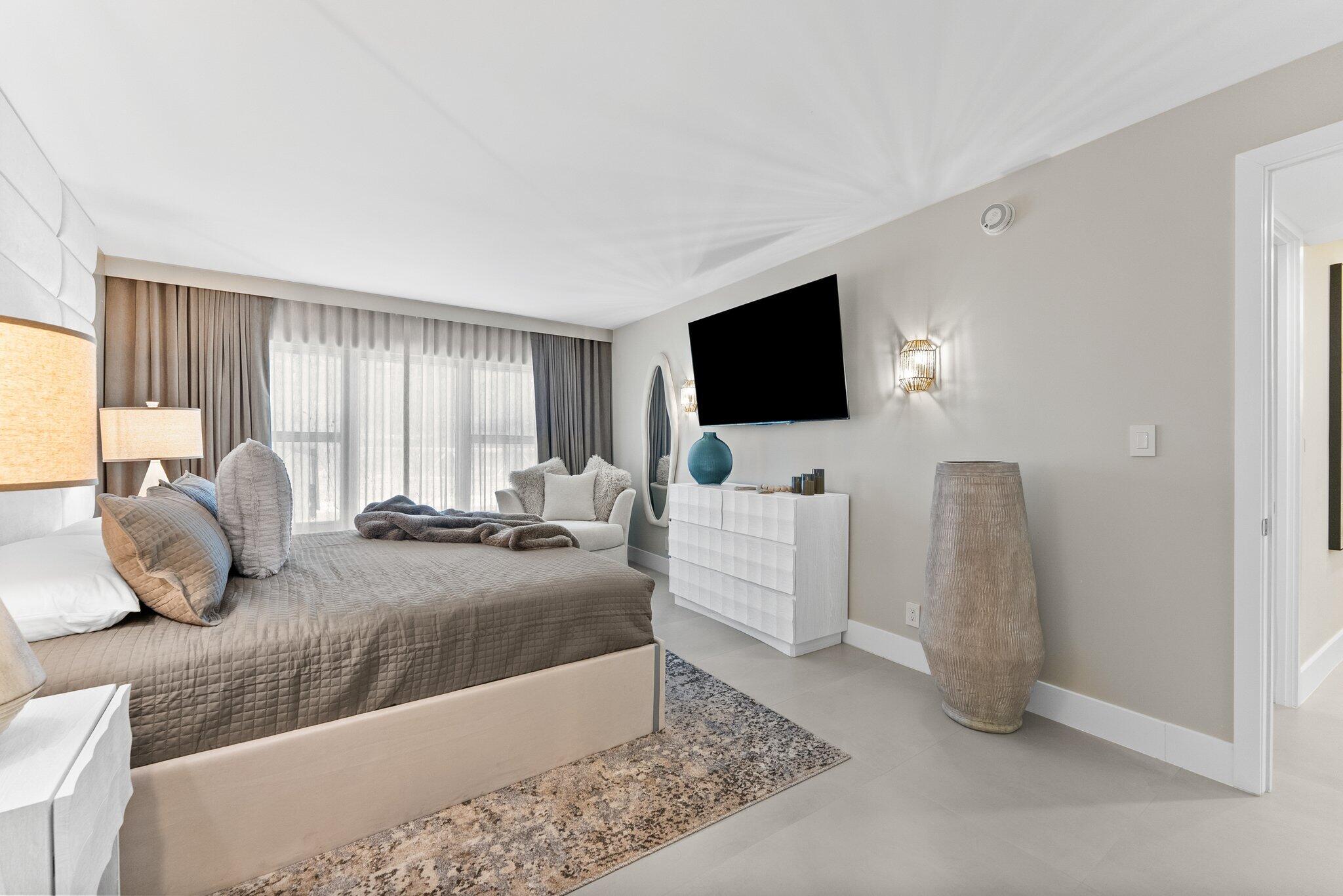 875 East Camino Real, Unit 2G Boca Raton, FL 33432 - Photo 20 of 55 a bedroom with a bed and flat screen tv