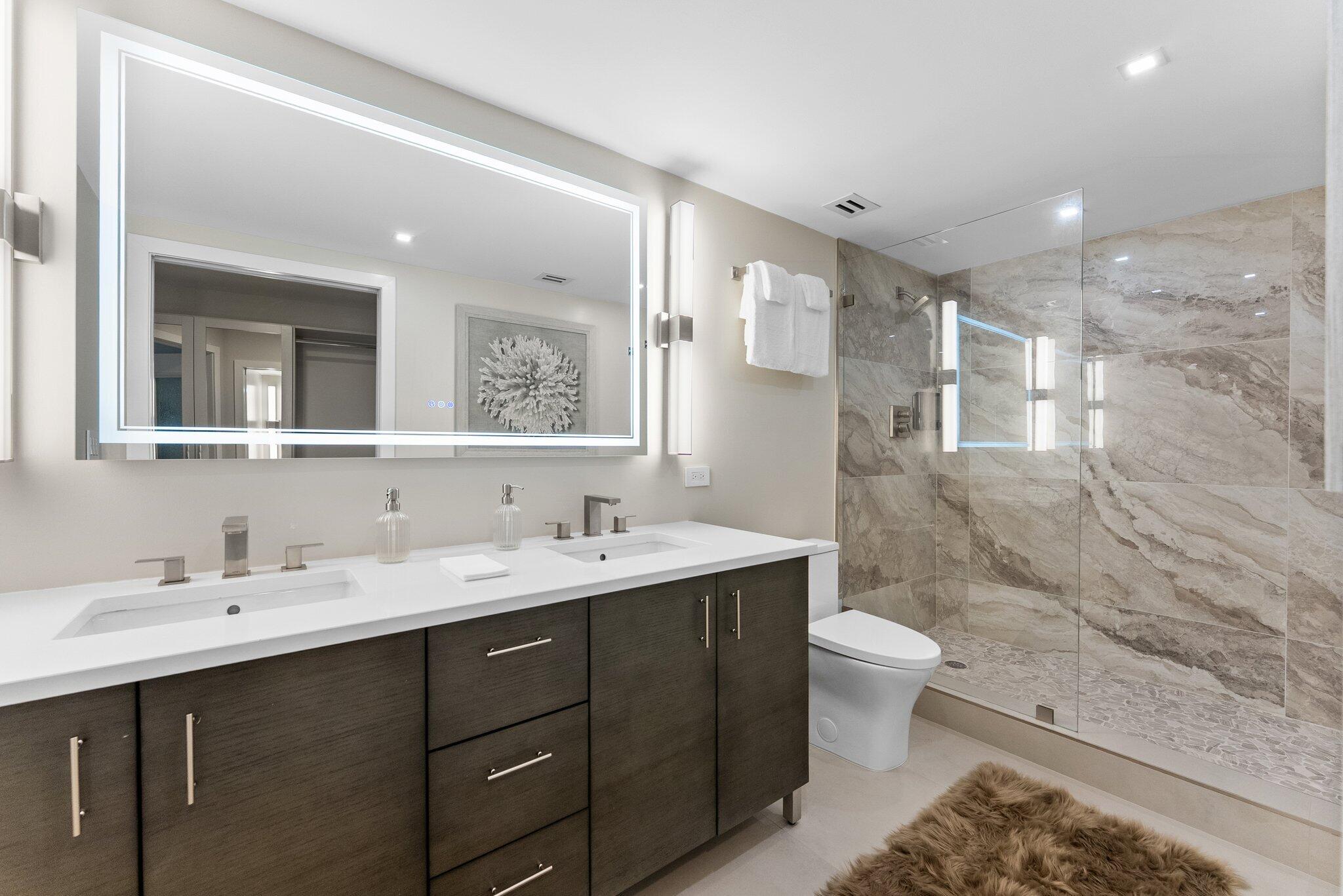 875 East Camino Real, Unit 2G Boca Raton, FL 33432 - Photo 22 of 55 a bathroom with a double vanity sink mirror and toilet